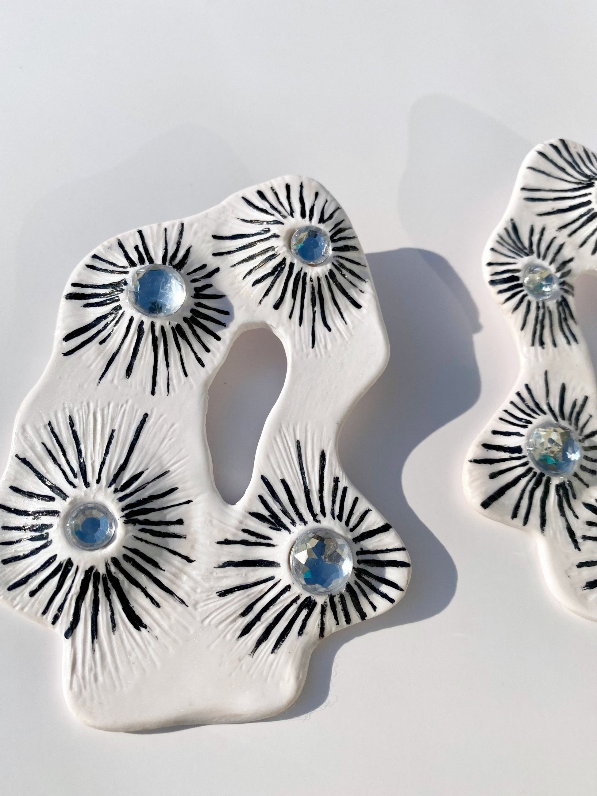 The Celeste Statement Earrings made with polymer clay and hand painted with black paint and added faux diamond jewels 